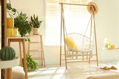 Photo of Comfortable hammock chair in stylish room. Home interior