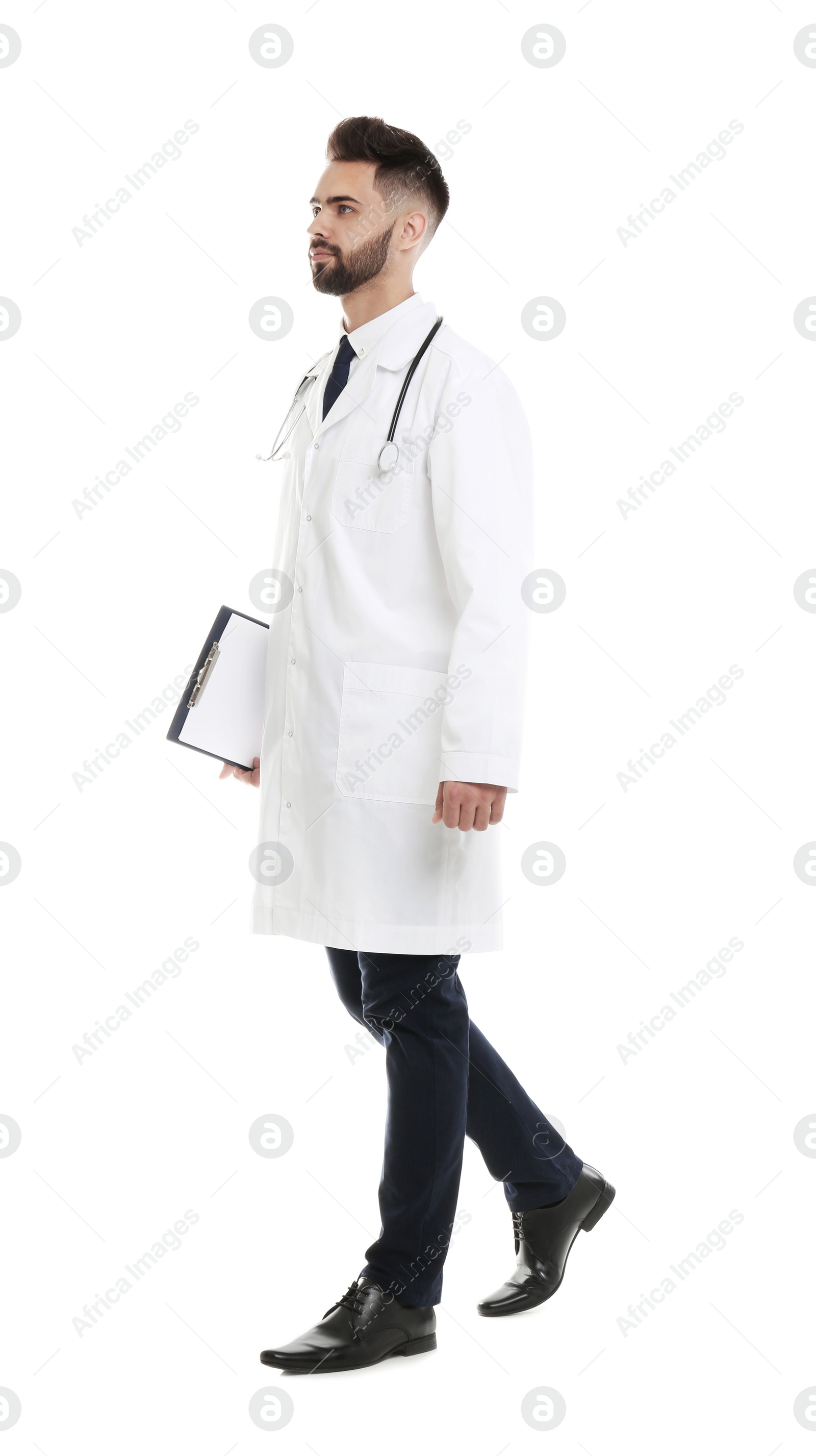 Photo of Young male doctor in uniform with clipboard isolated on white