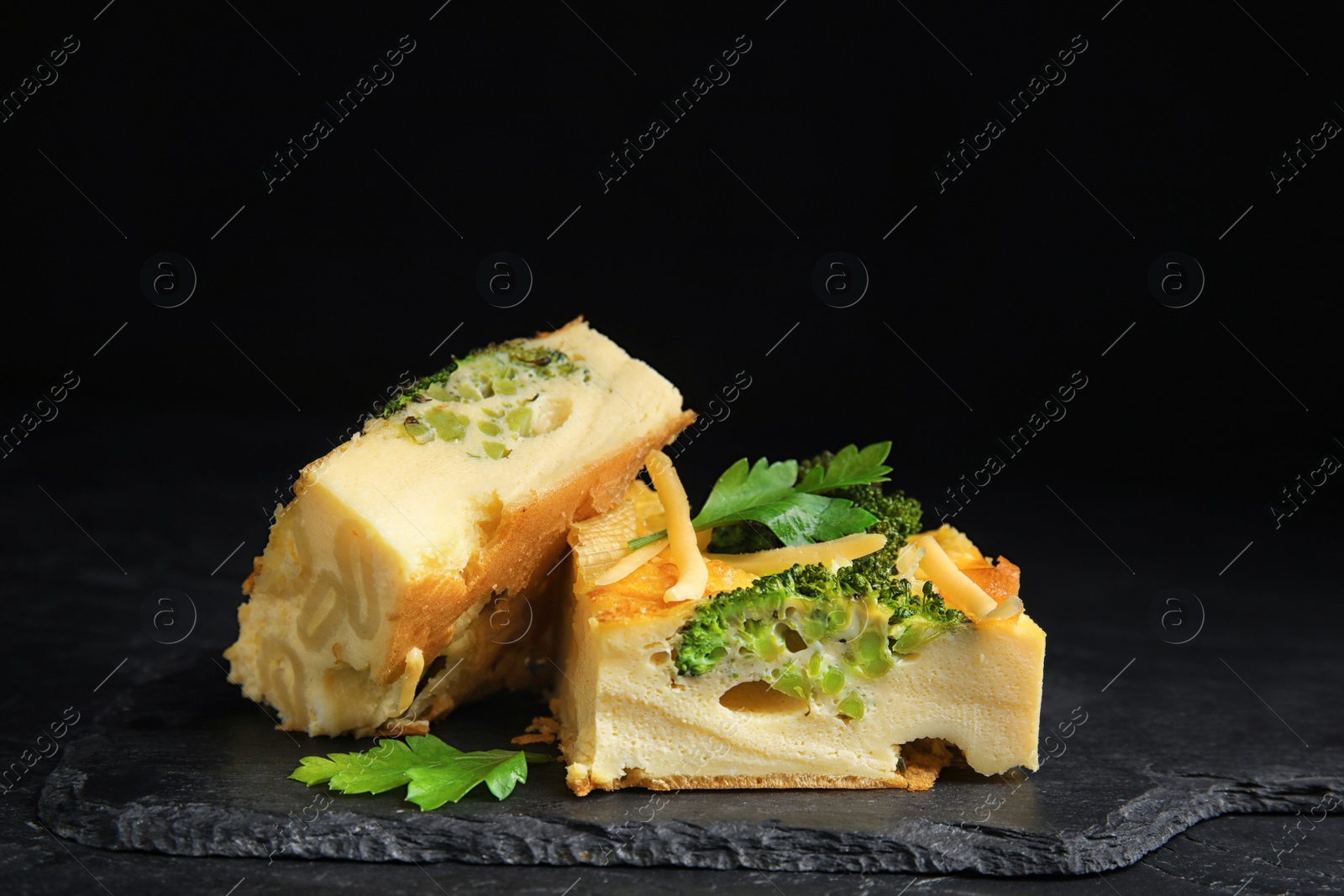 Photo of Tasty broccoli casserole served on black table