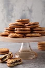 Photo of Tasty sandwich cookies with cream on grey table, closeup