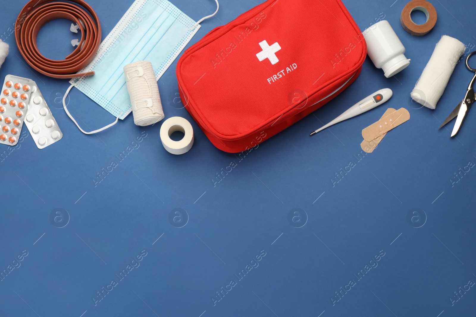 Photo of Flat lay composition with first aid kit on blue background, space for text