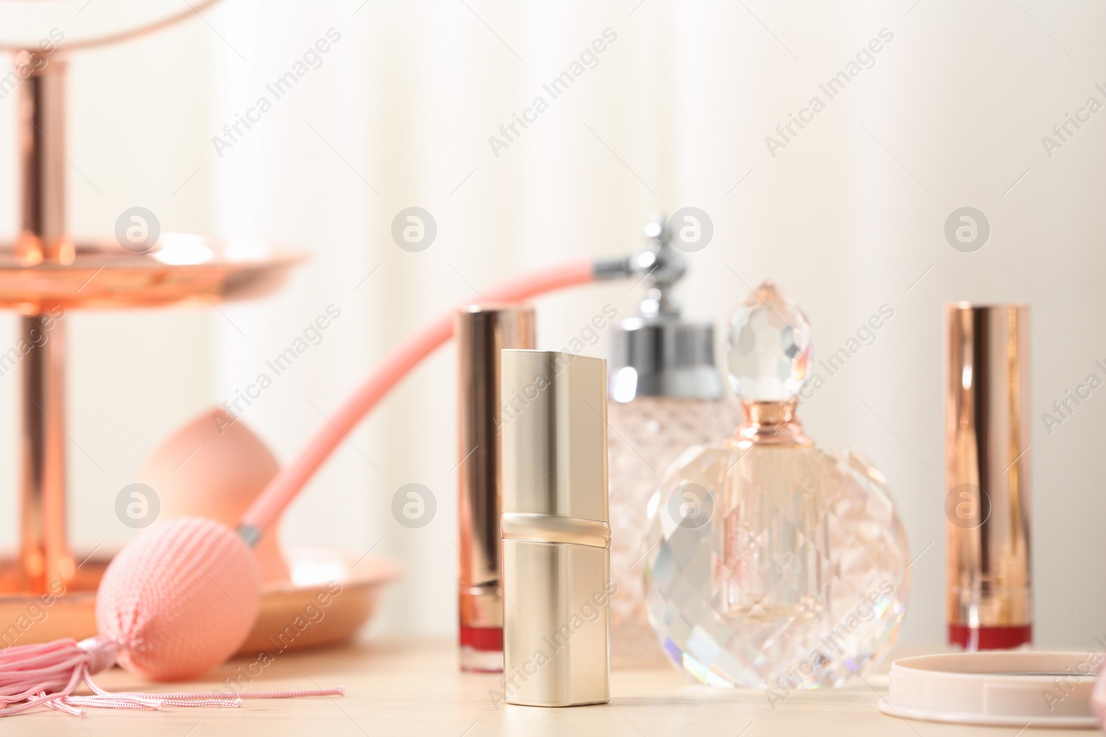 Photo of Different lipsticks and perfume bottle on dressing table