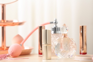 Photo of Different lipsticks and perfume bottle on dressing table