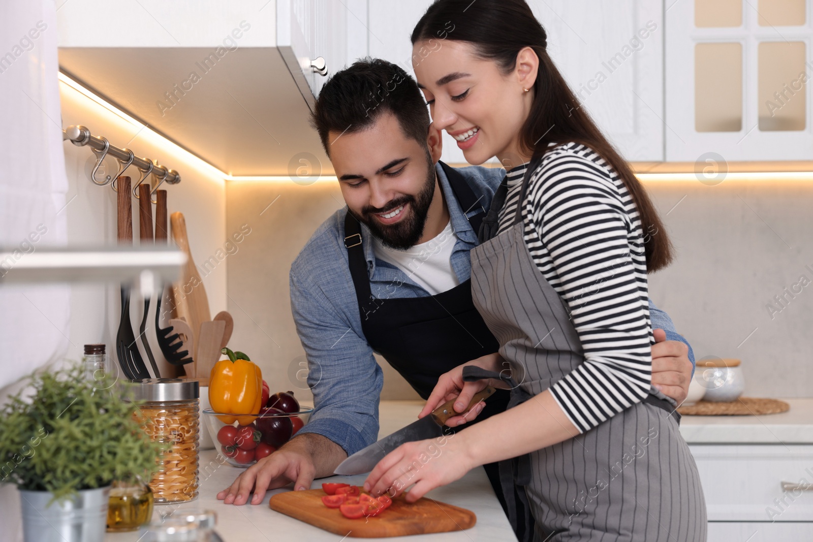 Photo of Happy lovely couple cooking together in kitchen