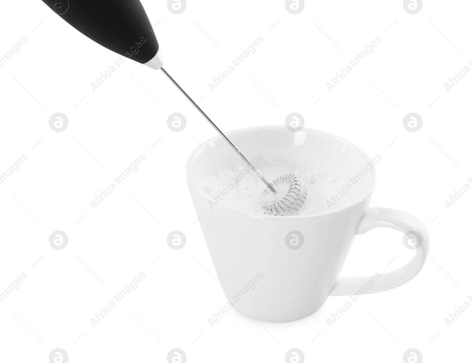 Photo of Whisking milk in cup with mini mixer (frother wand) isolated on white