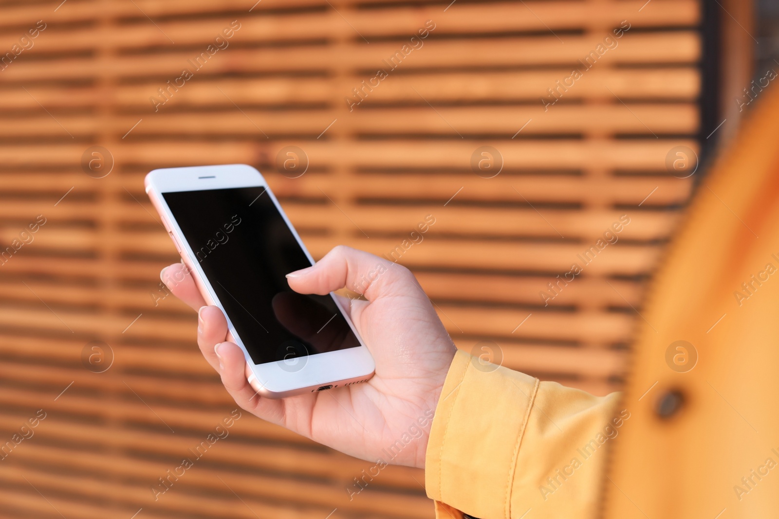 Photo of Young woman using phone outdoors, closeup