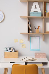 Comfortable workplace with wooden furniture and books