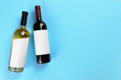 Photo of Bottles of wine on colorful background, flat lay. Space for text