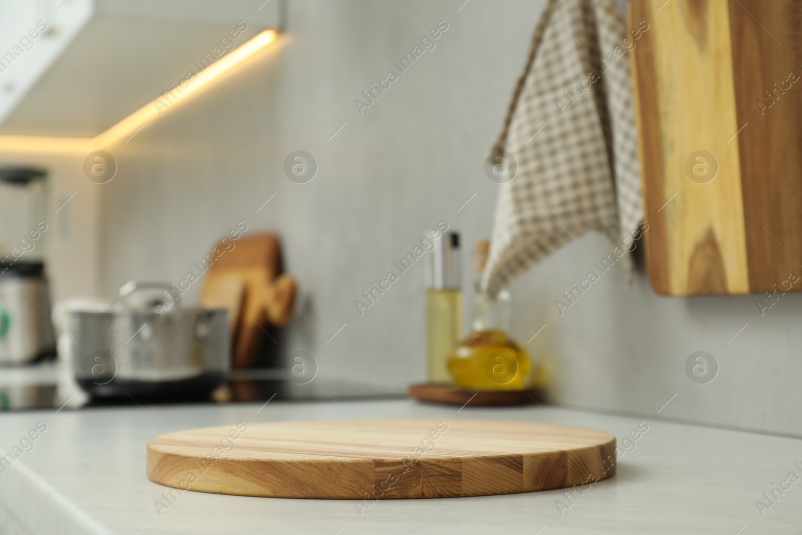 Photo of Wooden cutting board on white countertop in kitchen. Space for text