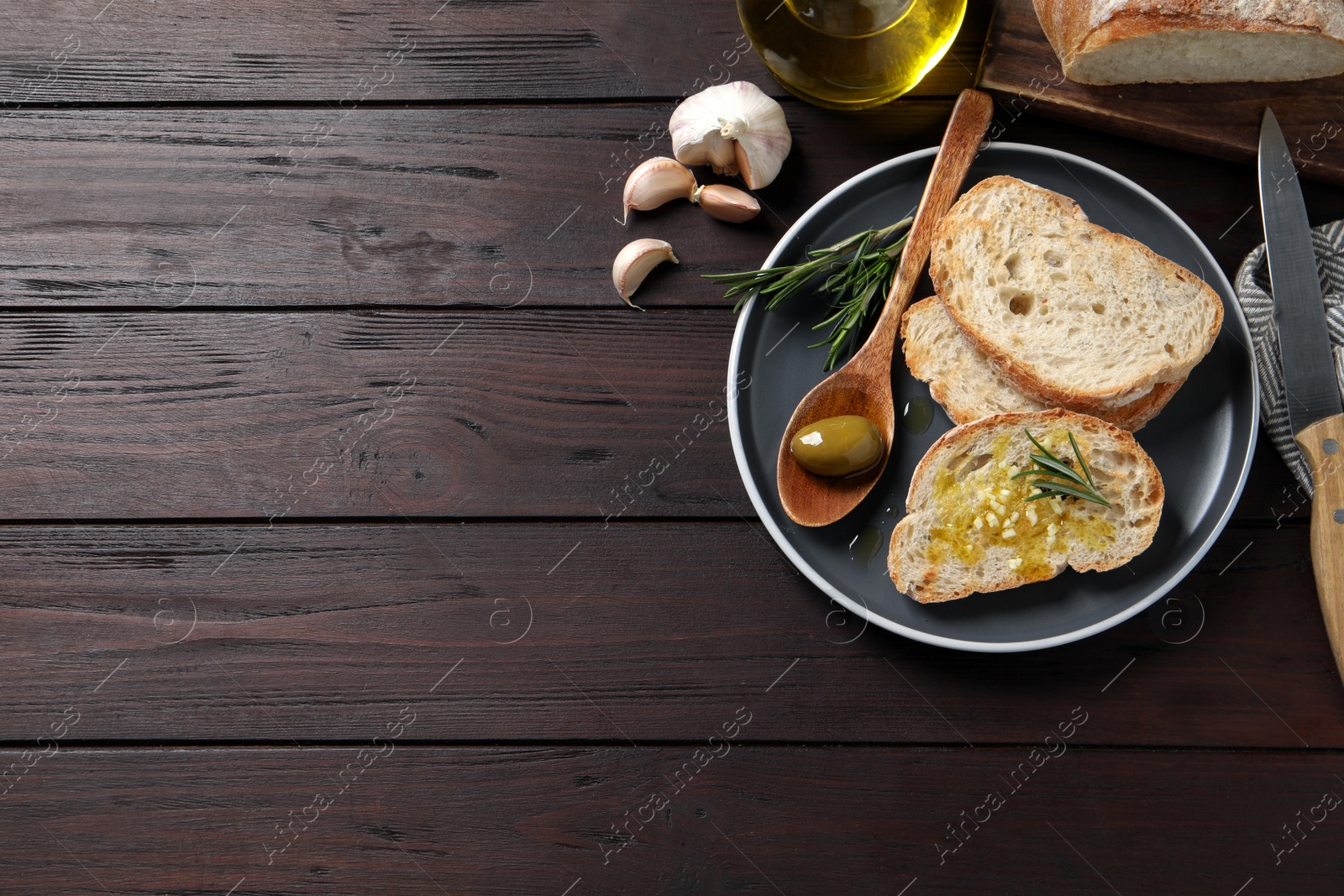 Photo of Tasty bruschettas with oil on wooden table, flat lay. Space for text