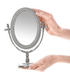 Woman holding vintage mirror against white background