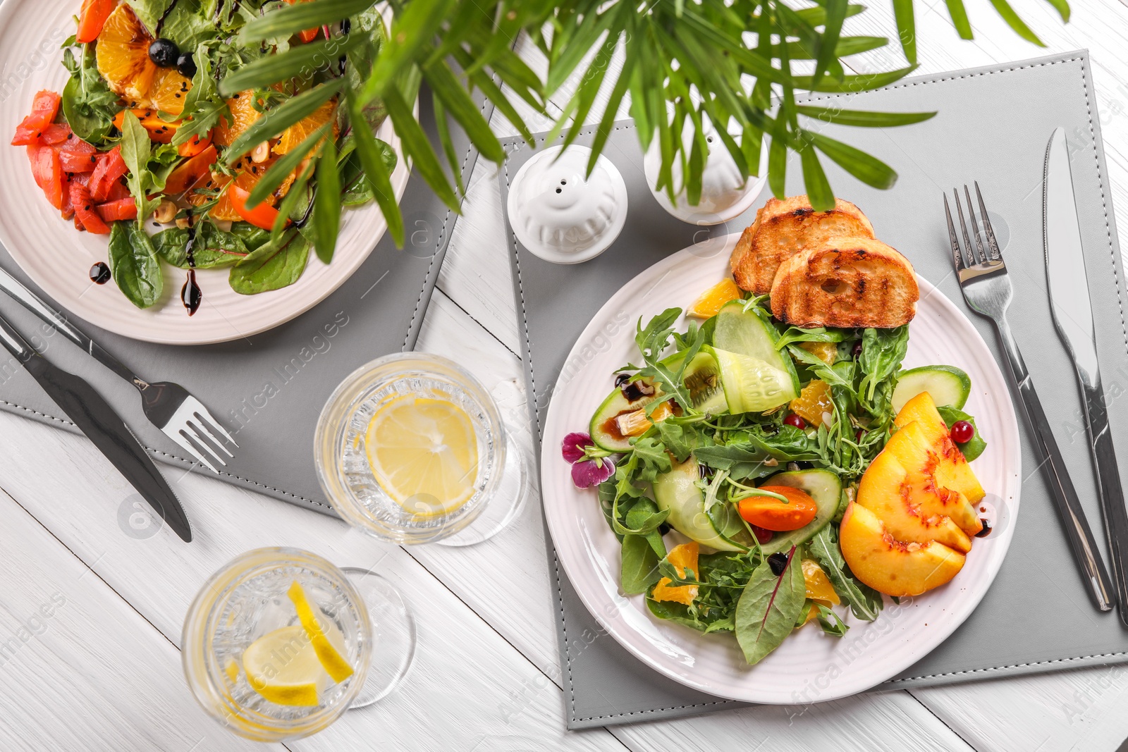 Photo of Delicious salad with fruits and vegetables served on white wooden table, flat lay