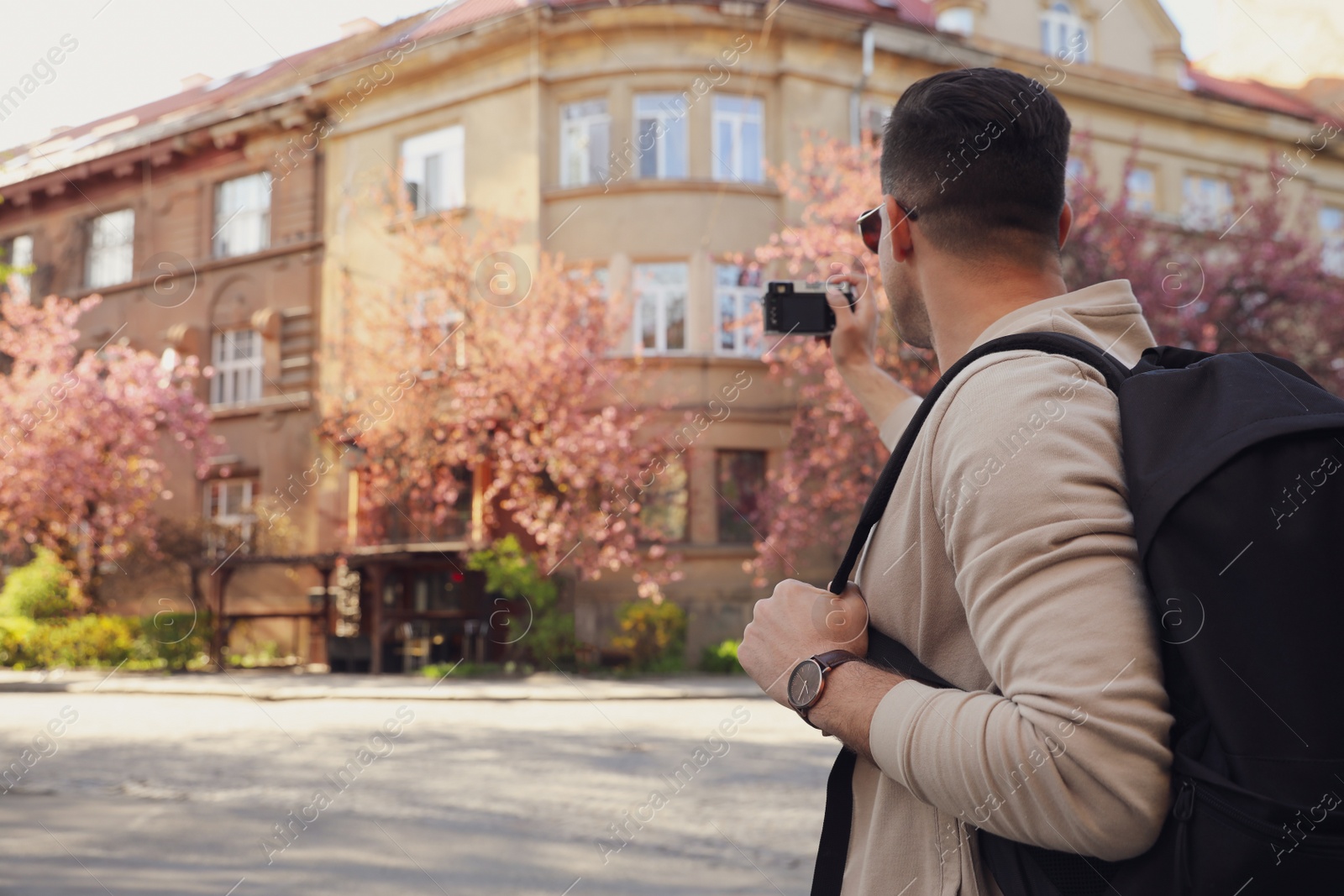 Photo of Male tourist taking photo of building on city street