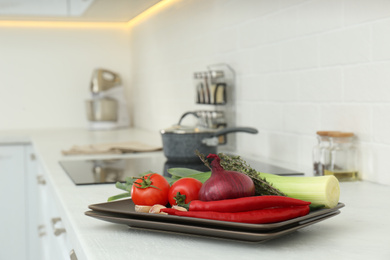 Different fresh vegetables on countertop in kitchen