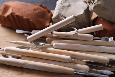 Photo of Clay and set of modeling tools on black table, closeup