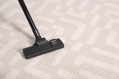 Photo of Hoovering floor with modern vacuum cleaner, closeup. Space for text