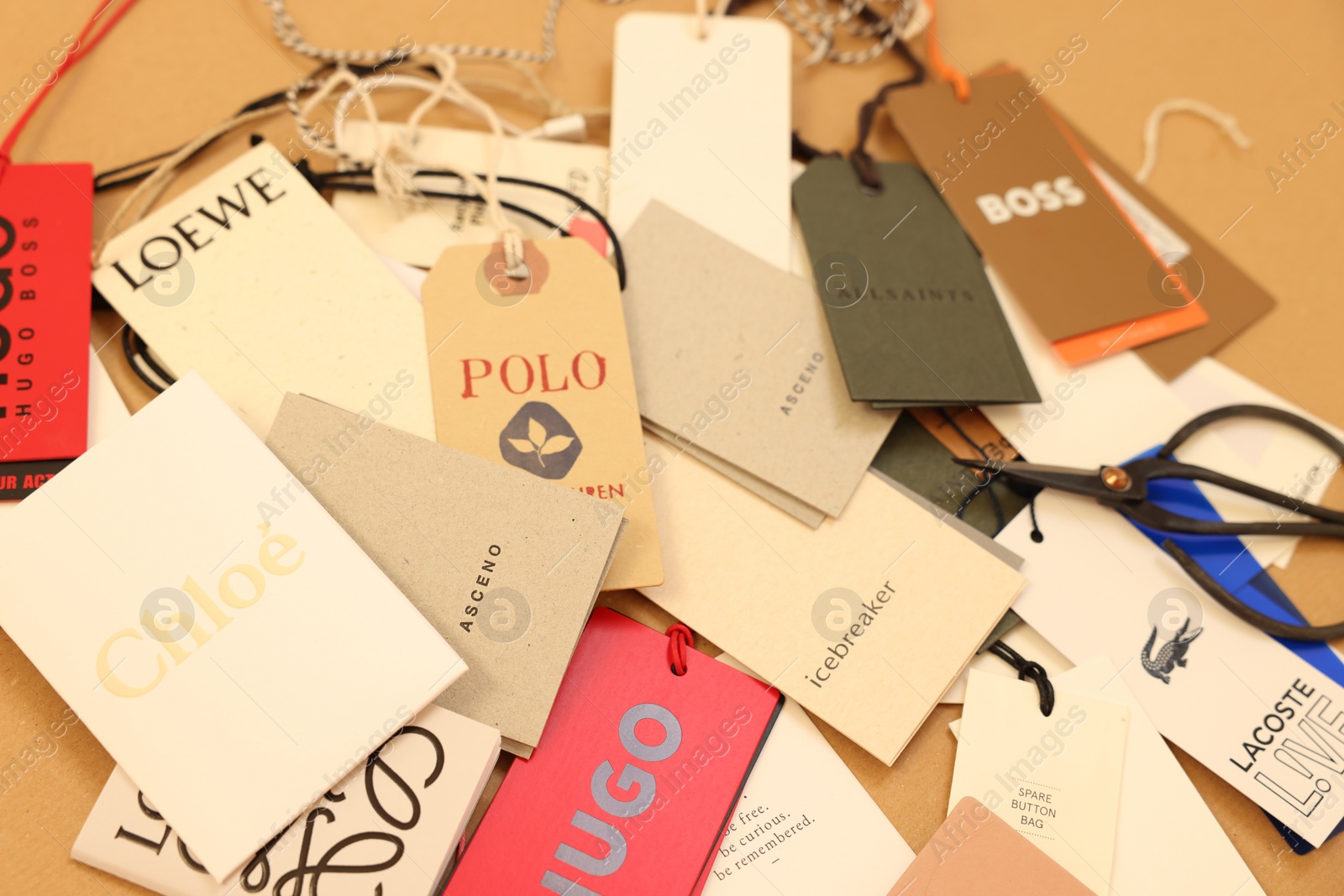 Photo of Leiden, Netherlands - December 6, 2023: Different clothing tags and scissors on kraft paper sheet, closeup