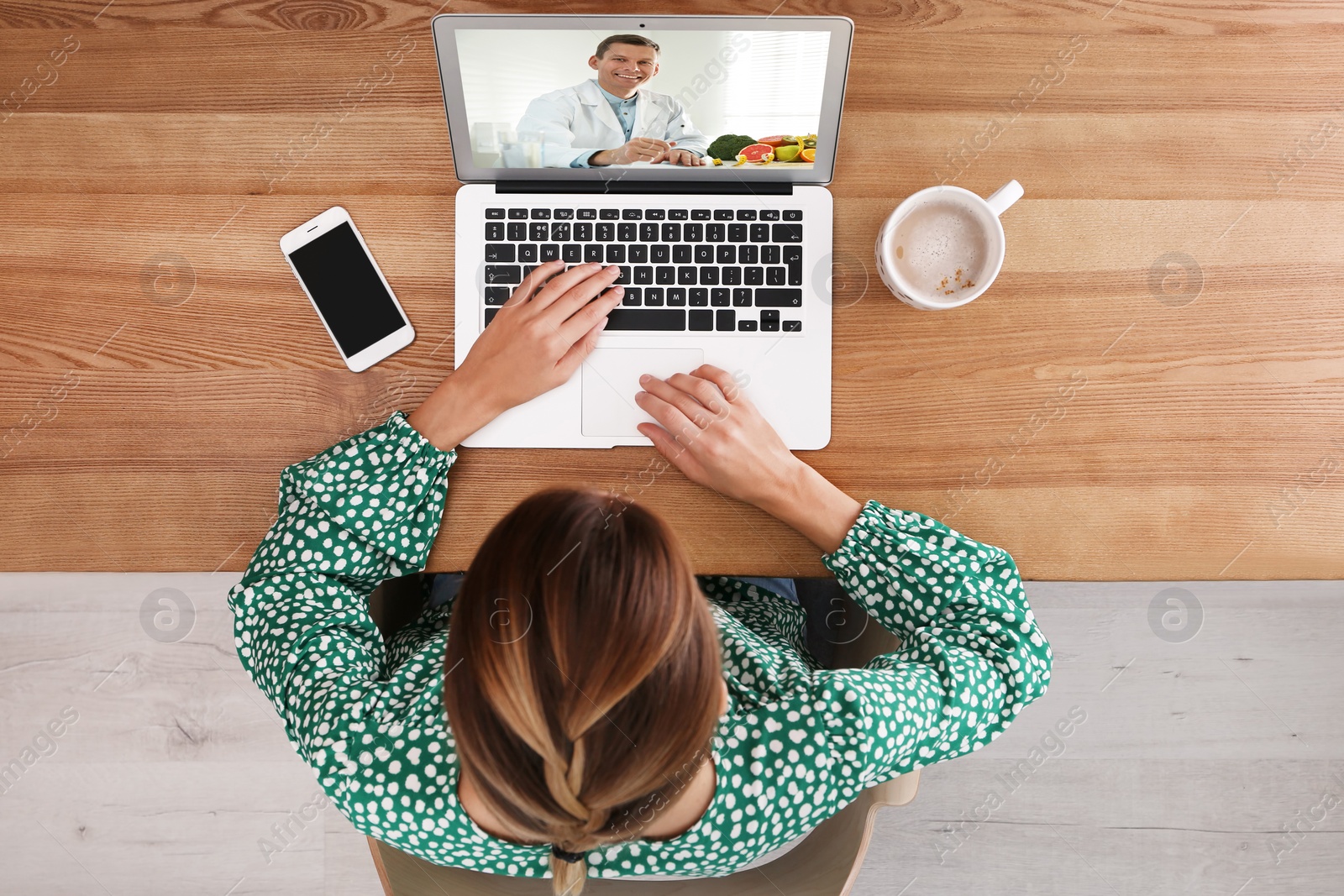 Image of Woman using laptop for online consultation with nutritionist via video chat, top view