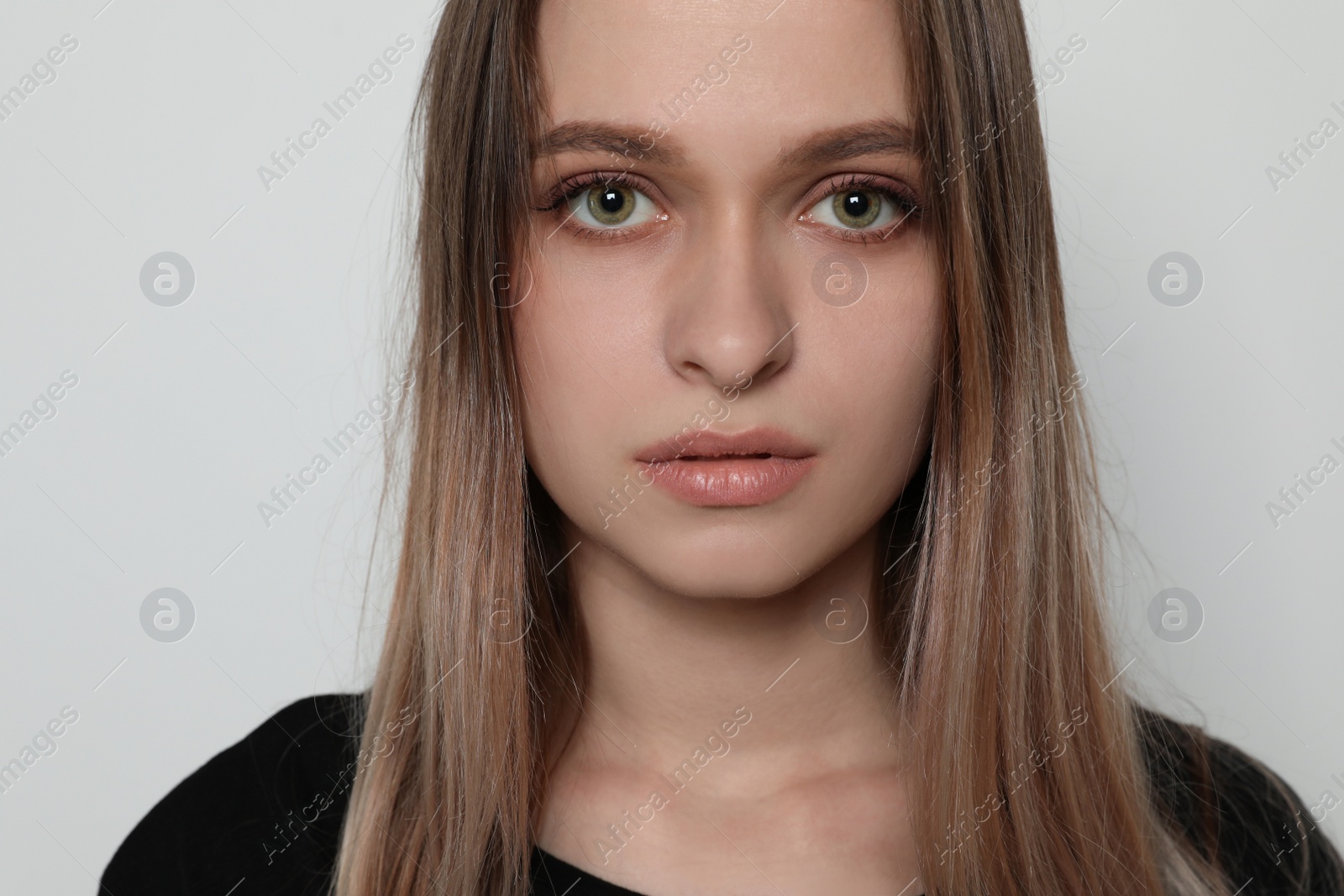 Photo of Abused young woman on light background. Stop violence