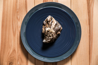 Photo of Fresh oyster on wooden table, top view