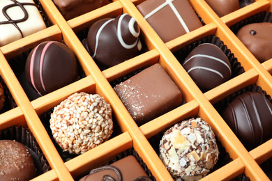 Photo of Box with different chocolate candies as background, closeup