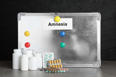 Photo of Magnetic board with word Amnesia and drugs on light grey table