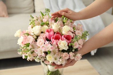 Woman with beautiful bouquet of fresh flowers at home, closeup