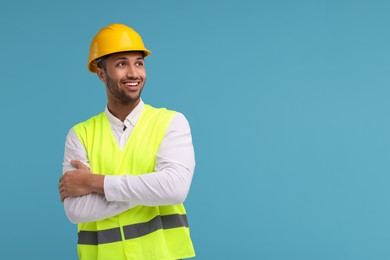 Engineer in hard hat on light blue background, space for text