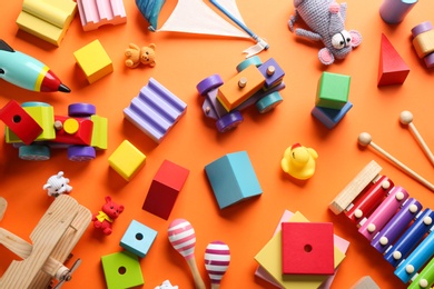 Flat lay composition with different toys on orange background