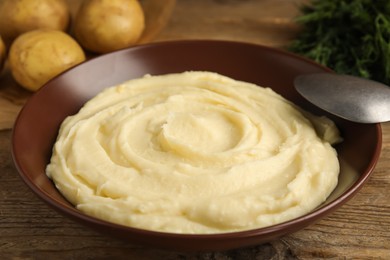 Photo of Freshly cooked homemade mashed potatoes on wooden table, closeup