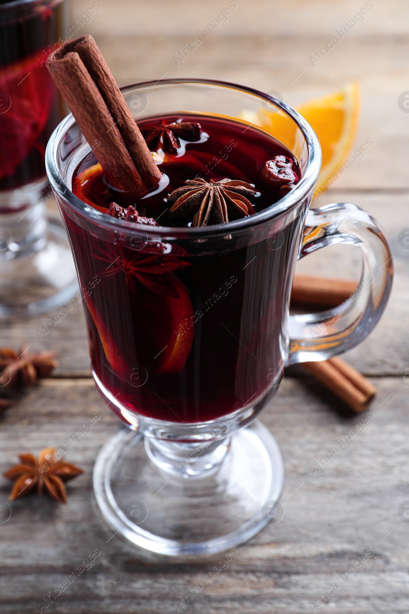 Photo of Delicious red mulled wine on wooden table, closeup