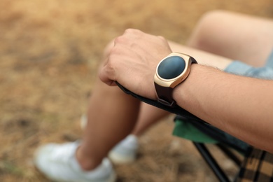 Photo of Man with stylish smart watch outdoors, closeup