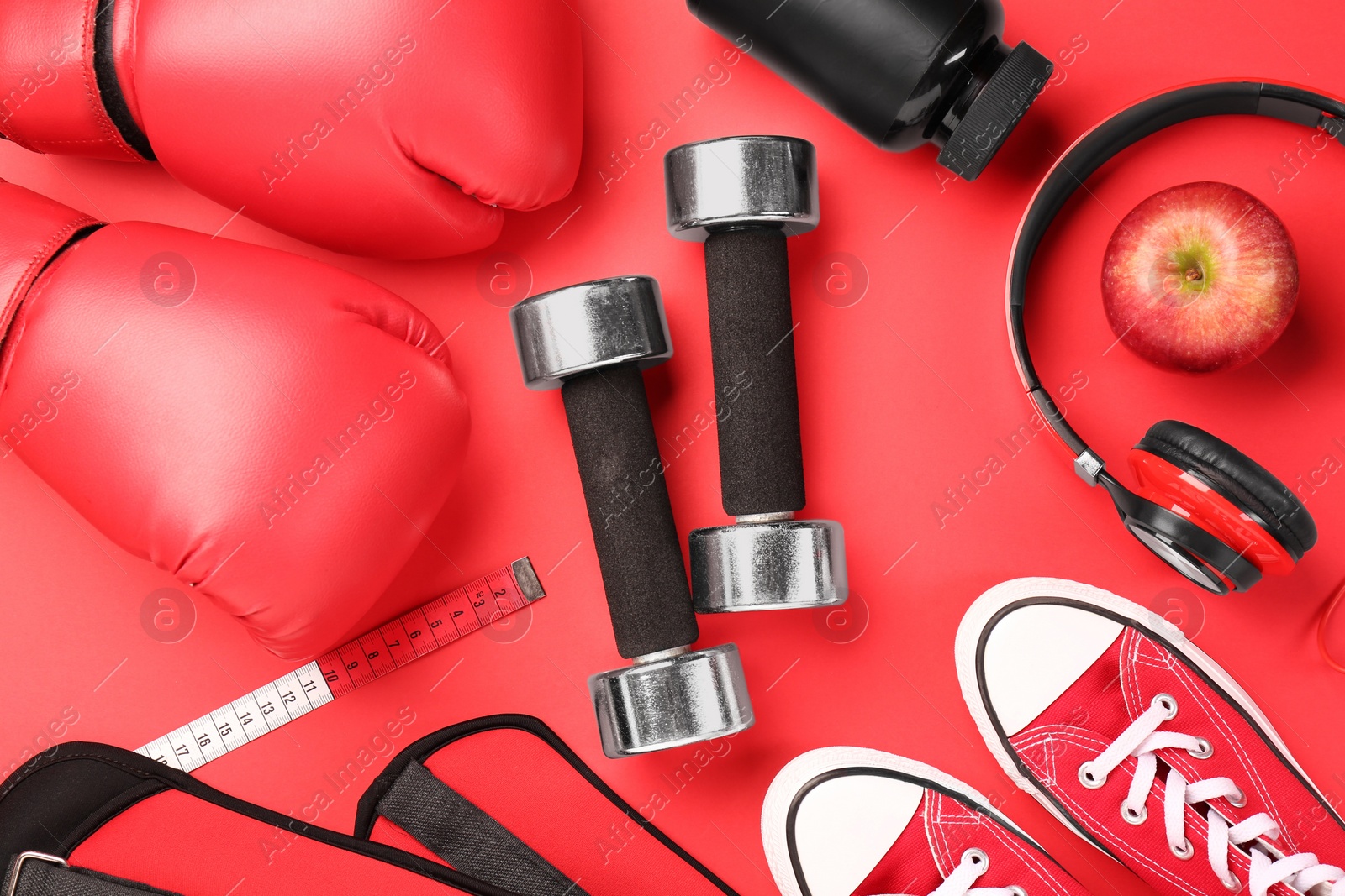 Photo of Flat lay composition with dumbbells on red background