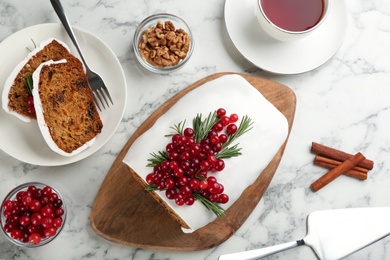 Traditional Christmas cake and ingredients on white marble table, flat lay. Classic recipe