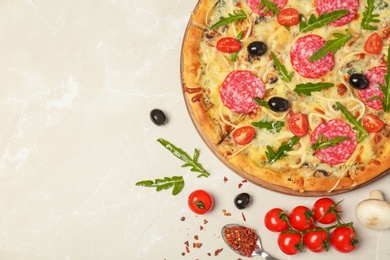 Delicious pizza with tomatoes and sausage on table