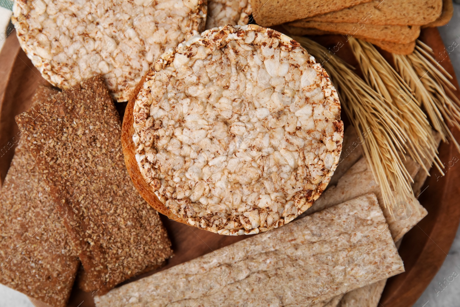 Photo of Rye crispbreads, rice cakes and rusks on table, closeup. Flat lay