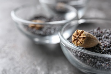 Bowl with dry poppy head and seeds on table, closeup