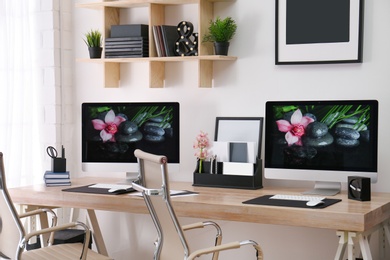 Modern workplace with large desk and computers in room. Stylish interior