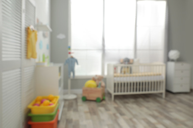 Blurred view of baby room with stylish furniture