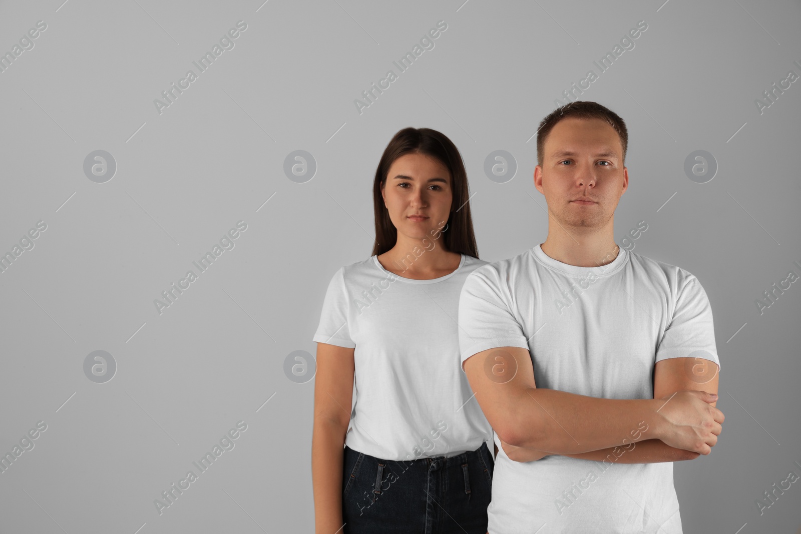 Photo of Portrait of young woman and man on light background. Space for text