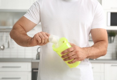 Photo of Man preparing protein shake in kitchen, closeup