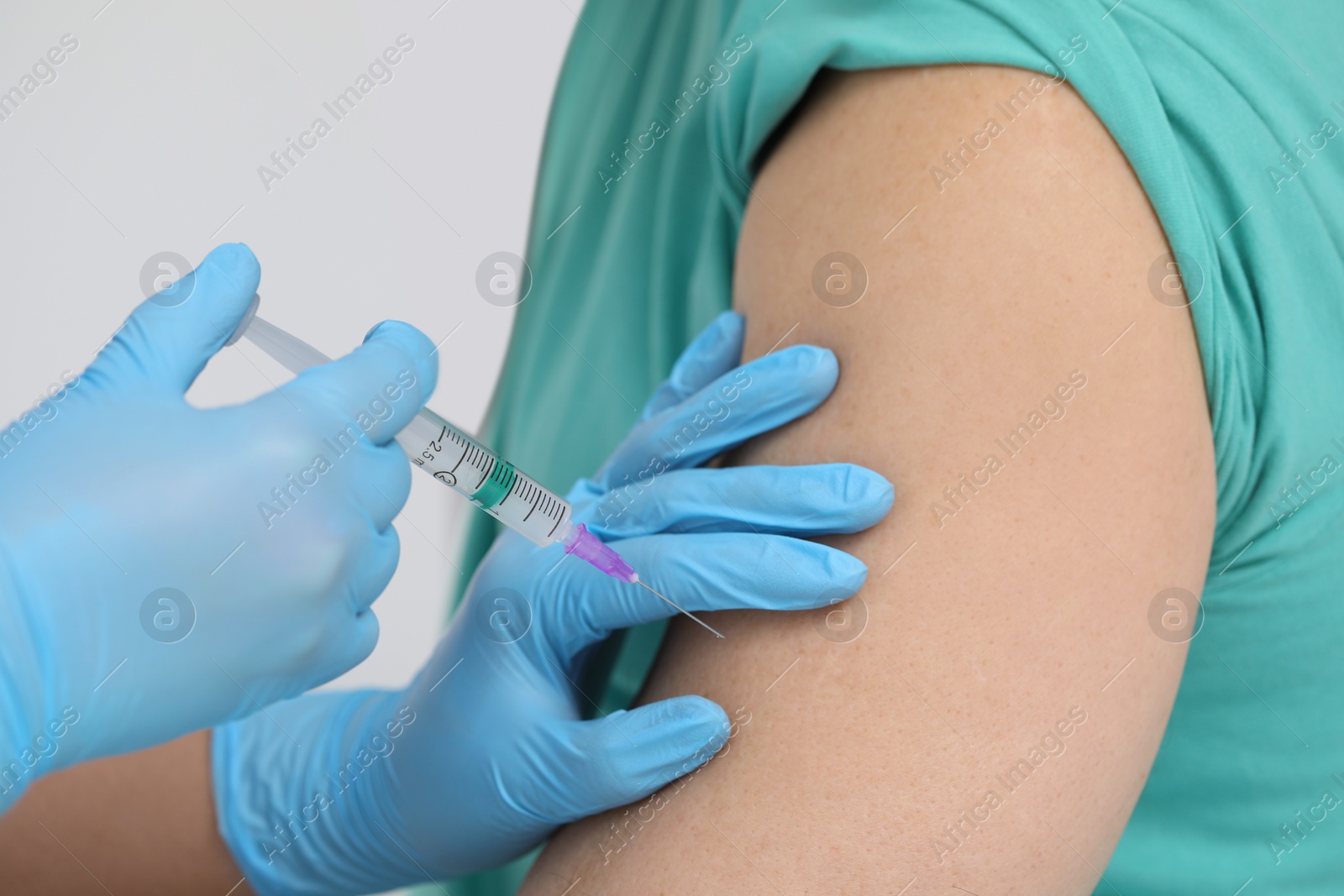 Photo of Doctor giving hepatitis vaccine to patient in clinic, closeup