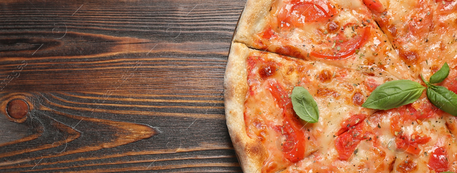 Image of Top view of hot delicious pizza on wooden table, space for text. Banner design 