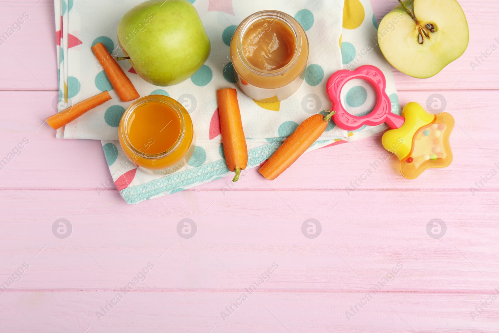 Photo of Healthy baby food in jars and fresh ingredients on pink wooden table, flat lay. Space for text