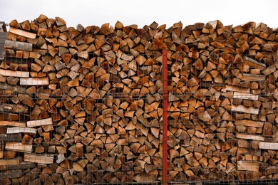 Photo of Stacked firewood outdoors. Heating house in winter