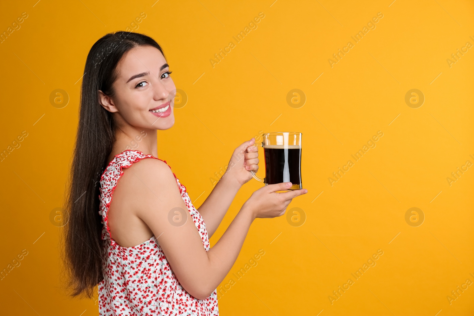 Photo of Beautiful woman with cold kvass on yellow background. Traditional Russian summer drink