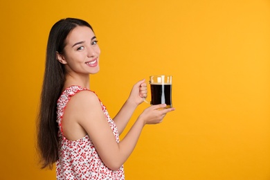 Beautiful woman with cold kvass on yellow background. Traditional Russian summer drink