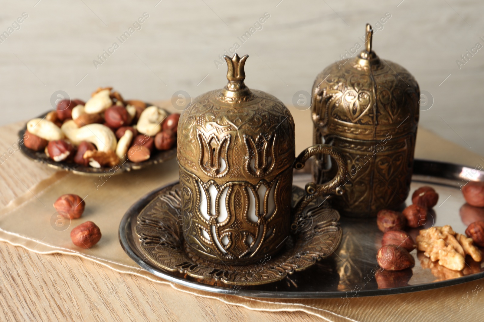 Photo of Tea and nuts served in vintage tea set on wooden table. Space for text