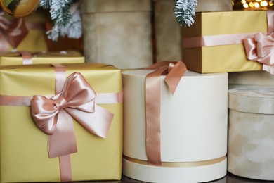 Many gift boxes under decorated Christmas tree at home, closeup
