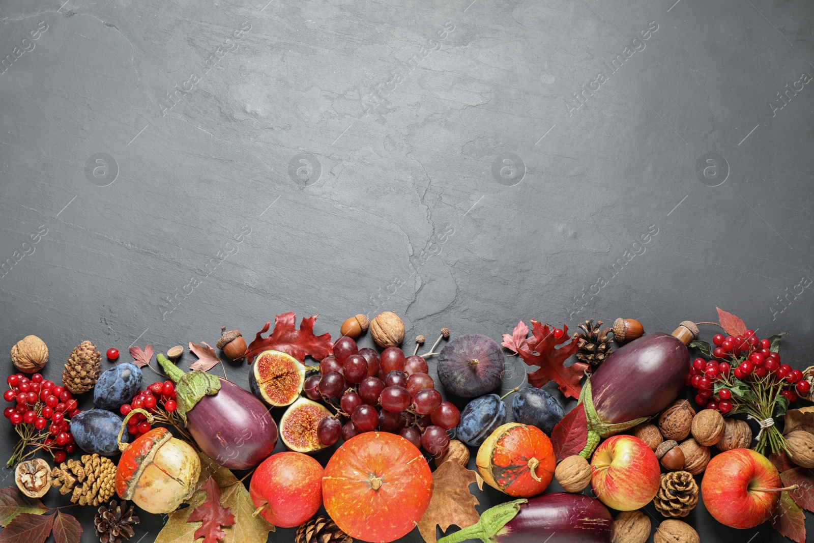 Photo of Flat lay composition with autumn vegetables and fruits on grey background, space for text. Happy Thanksgiving day